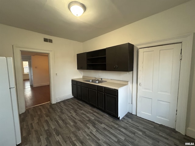 kitchen with sink, dark wood-type flooring, and white refrigerator