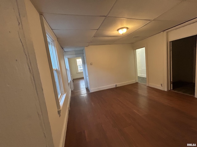 unfurnished room with a drop ceiling and dark hardwood / wood-style flooring