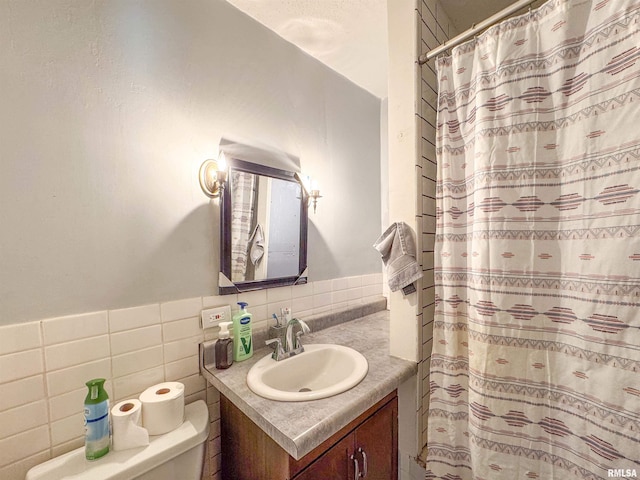 bathroom featuring vanity, toilet, and tile walls