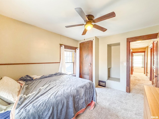 bedroom featuring multiple windows, ceiling fan, and light carpet