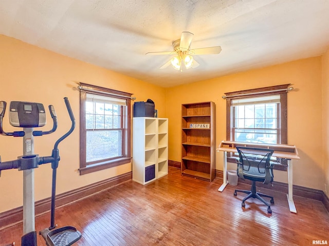 home office featuring hardwood / wood-style floors, plenty of natural light, ceiling fan, and a textured ceiling