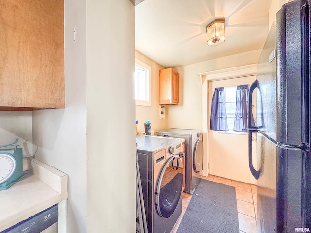 clothes washing area featuring separate washer and dryer and light tile patterned floors