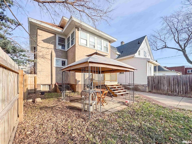 back of house with a gazebo and a patio area