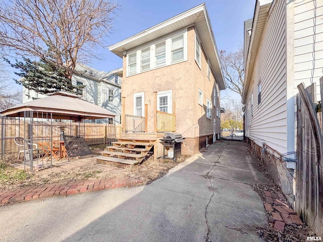 back of property featuring a gazebo