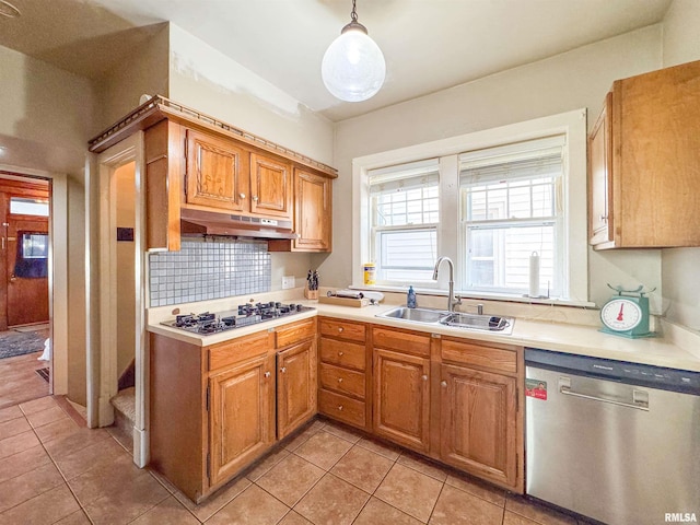 kitchen featuring pendant lighting, dishwasher, white gas stovetop, sink, and light tile patterned flooring