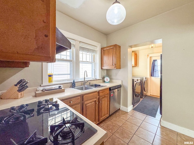 kitchen with sink, washer and dryer, light tile patterned floors, pendant lighting, and dishwasher