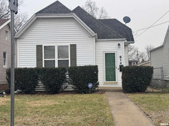 bungalow-style home with a front lawn