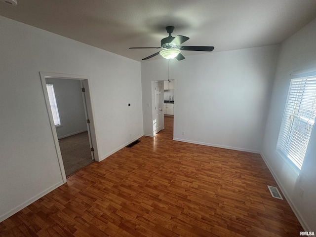 spare room with ceiling fan and dark hardwood / wood-style floors