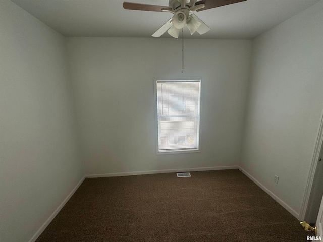 empty room featuring ceiling fan and dark carpet