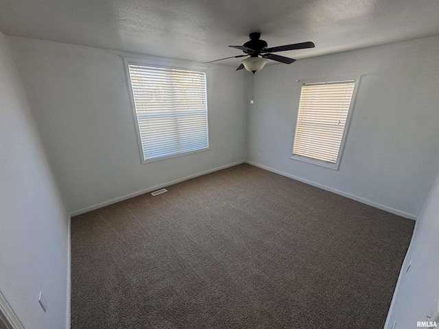 carpeted spare room featuring plenty of natural light, ceiling fan, and a textured ceiling