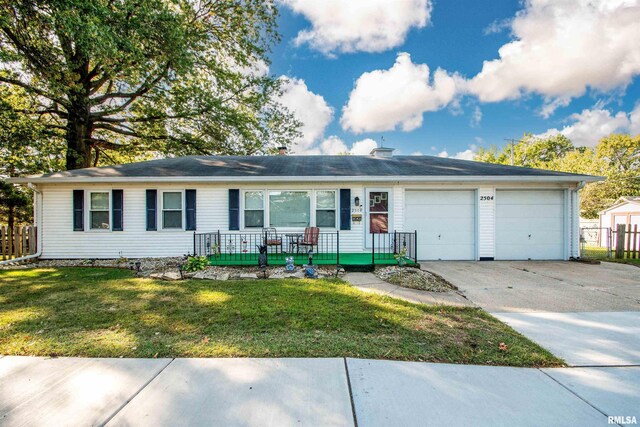 ranch-style home with covered porch, a garage, and a front lawn