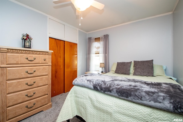 carpeted bedroom featuring ceiling fan, crown molding, and a closet