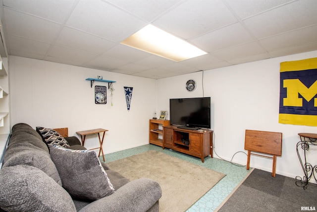 carpeted living room featuring a drop ceiling