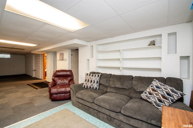 living room featuring a paneled ceiling, built in shelves, and carpet floors