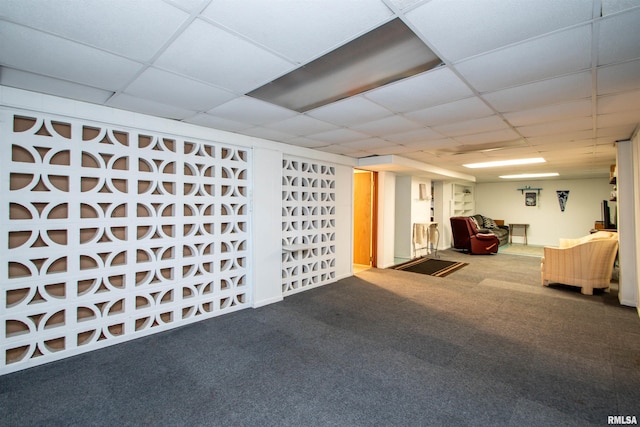 basement with a paneled ceiling and carpet flooring