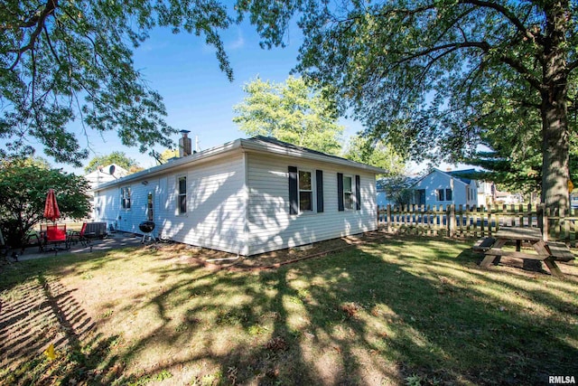 view of side of property with a yard and cooling unit