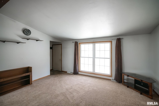 carpeted spare room with vaulted ceiling