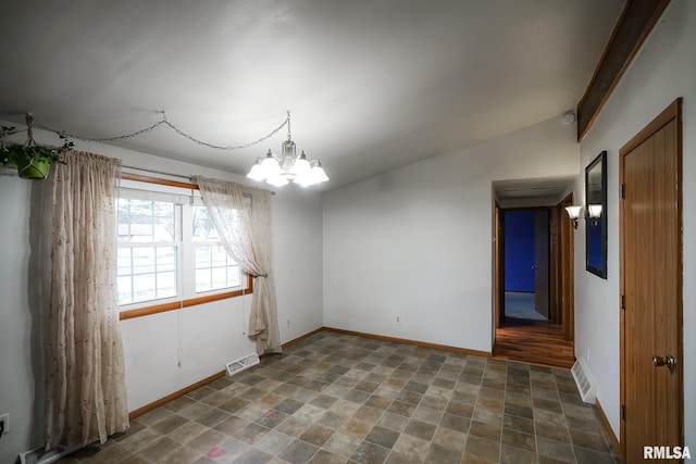 spare room with vaulted ceiling and a notable chandelier