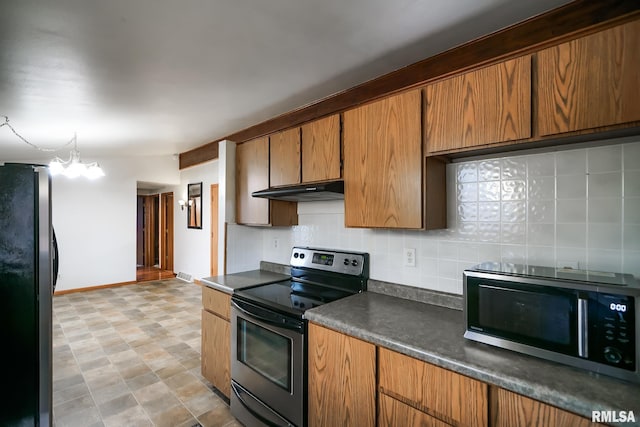 kitchen featuring decorative backsplash, appliances with stainless steel finishes, pendant lighting, and a notable chandelier