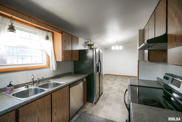 kitchen with backsplash, sink, an inviting chandelier, and appliances with stainless steel finishes