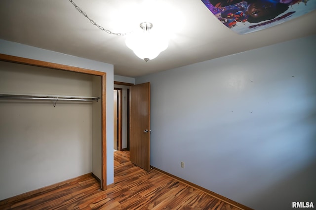 unfurnished bedroom featuring dark hardwood / wood-style flooring and a closet