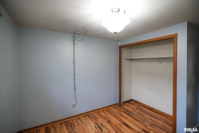 unfurnished bedroom featuring hardwood / wood-style floors and a closet