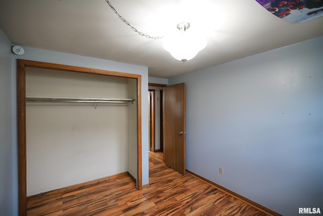 unfurnished bedroom featuring a closet and wood-type flooring