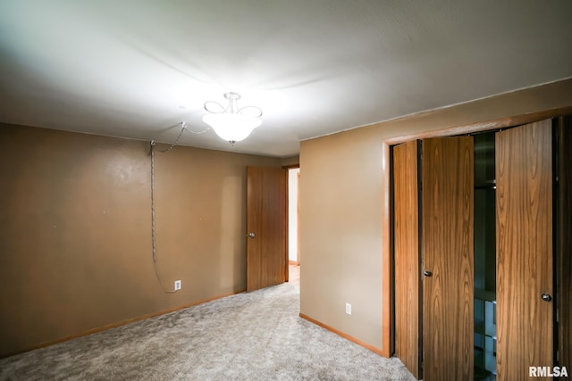 unfurnished bedroom featuring light carpet and a closet