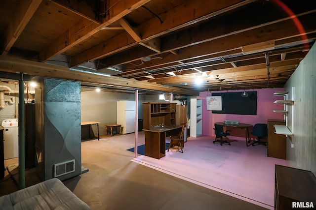 basement featuring washer / clothes dryer and white fridge