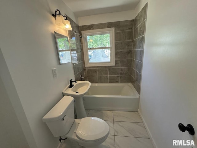 bathroom featuring toilet and tiled shower / bath