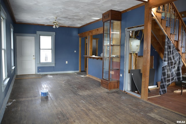 interior space with ceiling fan, dark hardwood / wood-style flooring, and ornamental molding