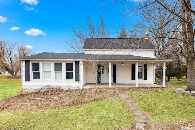 view of front of property with a shingled roof and a front yard