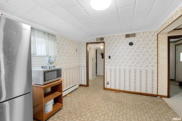 kitchen featuring crown molding, baseboard heating, and appliances with stainless steel finishes