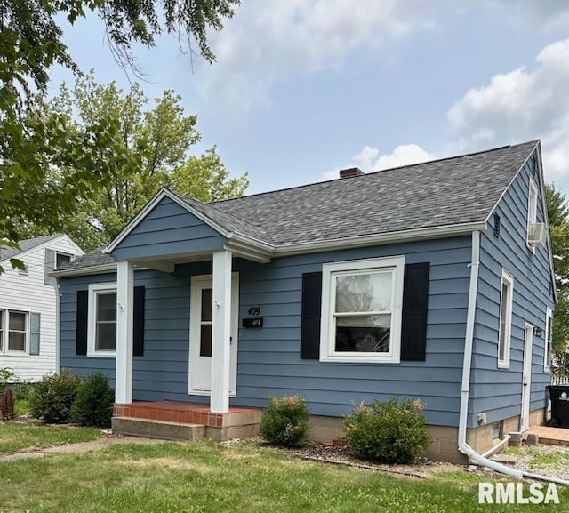 bungalow-style home with a front yard