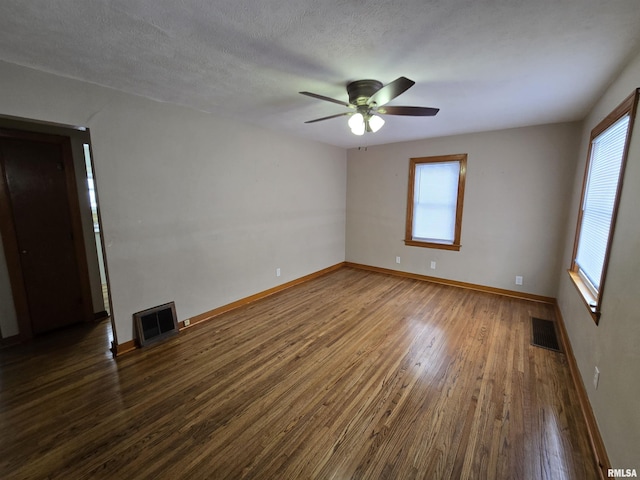 unfurnished room with dark hardwood / wood-style floors, ceiling fan, a textured ceiling, and a wealth of natural light