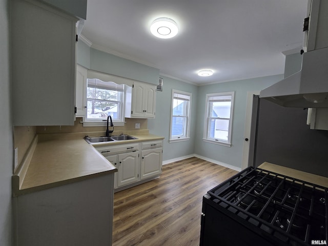 kitchen featuring white cabinetry, sink, a healthy amount of sunlight, hardwood / wood-style floors, and black range with gas cooktop