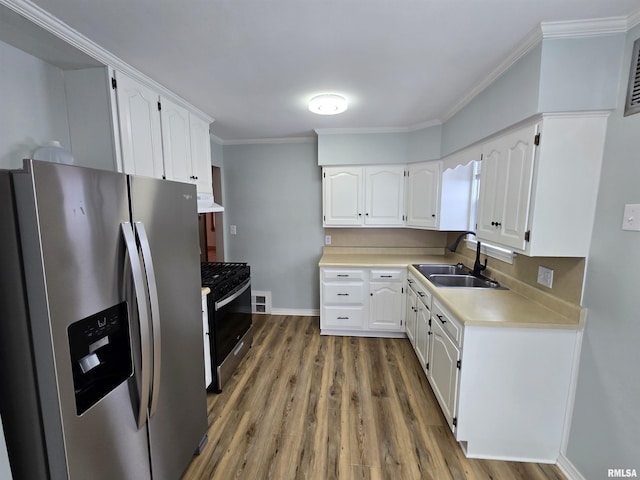 kitchen featuring gas stove, white cabinetry, sink, stainless steel fridge with ice dispenser, and ventilation hood