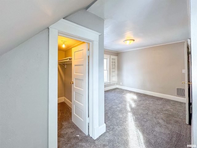 interior space featuring dark colored carpet and lofted ceiling