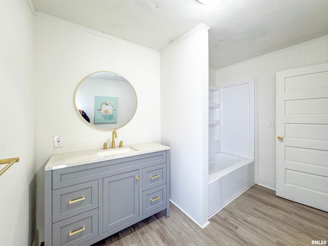 bathroom featuring vanity, hardwood / wood-style flooring, and crown molding