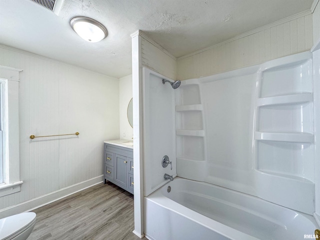 full bathroom with wood-type flooring, a textured ceiling, toilet, shower / washtub combination, and vanity