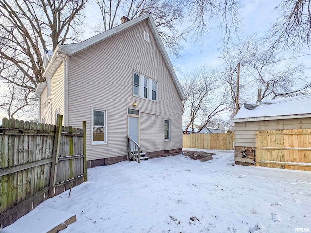 view of snow covered rear of property