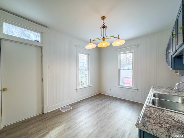 dining area featuring sink, a notable chandelier, and hardwood / wood-style flooring