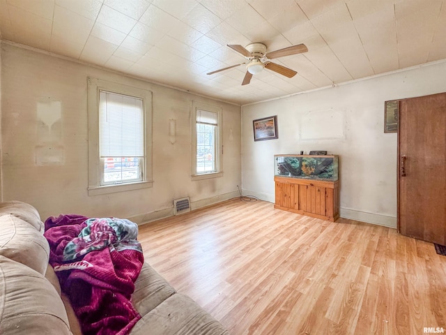 living area with ceiling fan, light hardwood / wood-style flooring, and crown molding