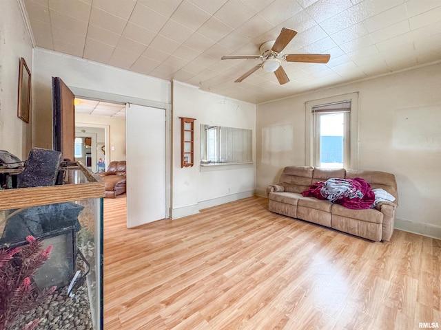 living room with a high end fireplace, light hardwood / wood-style floors, and ceiling fan