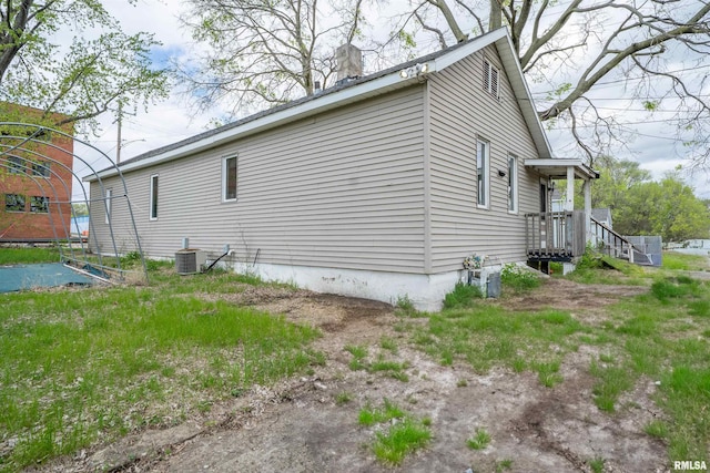 view of side of home featuring a chimney and cooling unit