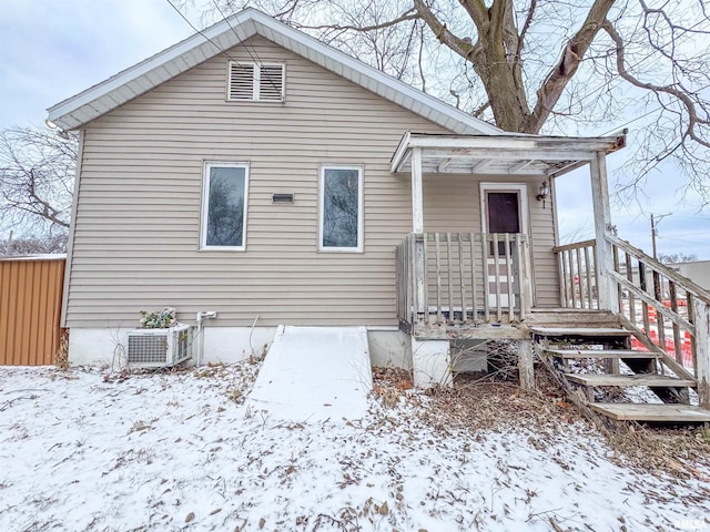 snow covered house with central AC