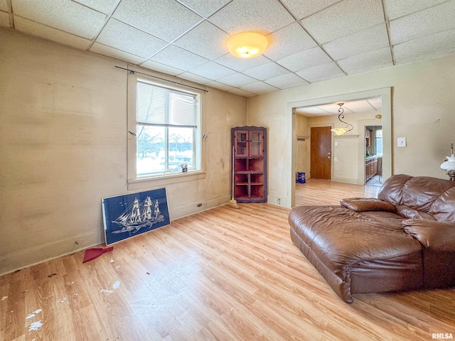 living room with wood-type flooring and a drop ceiling