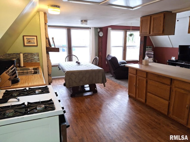 kitchen featuring dark hardwood / wood-style flooring, sink, decorative light fixtures, white range with gas stovetop, and lofted ceiling