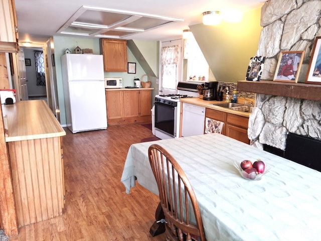 kitchen with wood-type flooring, white appliances, and sink