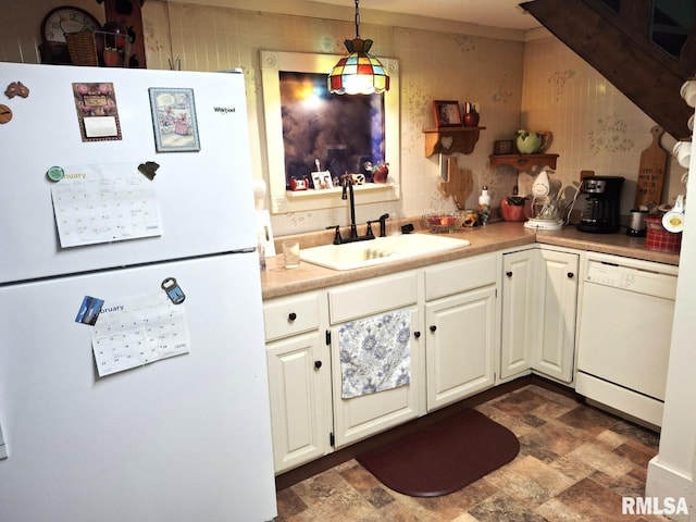 kitchen featuring white cabinetry, sink, hanging light fixtures, and white appliances